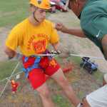A summer camper rappeling from a 30ft tower.