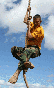 A summer camper climbs a rope