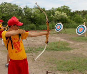 A MMA summer camper leaning archery