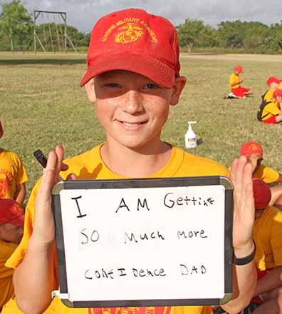 summer camper holding message for parents